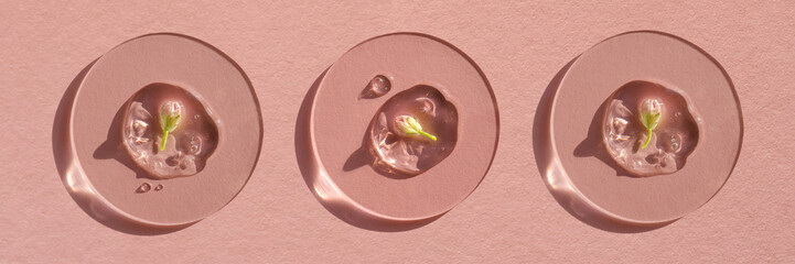 A drop of cosmetic gel with a flower on a pink background.