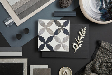 Flat lay of stylish architect moodboard composition with black, beige and grey samples of textile, paint, panels and tiles. Top view. Copy space. Template.