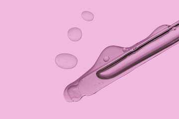 Pipette with cosmetic product in water with bubbles.