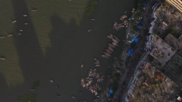 Aerial top down view of Buriganga river with ship terminal and boats. Drone flight bird's eye view shot