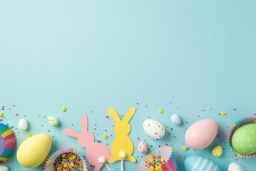 Top view photo of easter decorations easter bunny silhouettes multicolored easter eggs in paper baking molds and confectionery topping on isolated pastel blue background with blank space