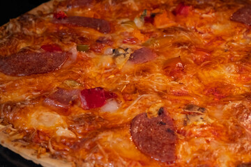 Burnt pizza with sausage, mushroom, pepper, cheese on tray in electric oven - close up, macro. Italian cuisine, failure, problem, fast food concept