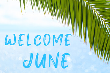 Fototapeta na wymiar Welcome June text on the background with palm leaf and blue sea. Template of a greeting card, postcard or advertisement of a tour agency. 