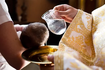 Fotobehang Infant baptism. Water is poured on the head of an infant. © Ruslan