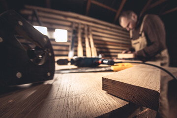 A man makes wood products with the help of special tools. Portrait of a young carpenter at work. Employment in the woodworking industry