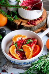 Baked salmon with tangerines in cranberry sauce in a white pan.style vintage