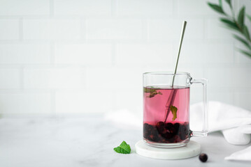 hot berry tea with blackcurrant and mint leaves in a glass mug