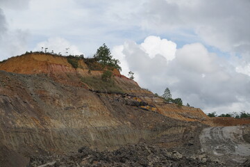 view of a coal mining area and seen in the distance an excavator climbing up the mountains during...