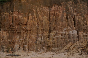 is a wall of earth created by human excavations, growing lush and green on top, former coal mining