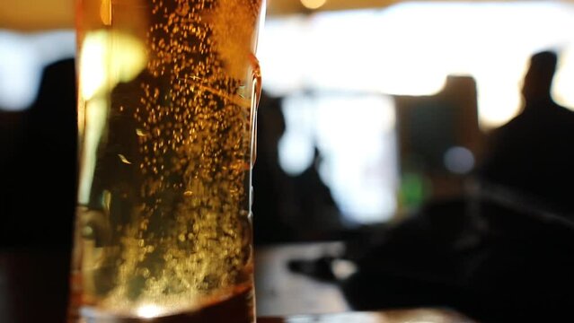 Close up footage of bubbles rising inside a glass of beer.