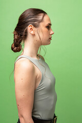 Young woman with gathered dark hair isolated on green