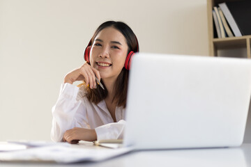 Happy smiling Asian woman working on laptop while meeting in online classroom. Internet work from home and online learning concepts.