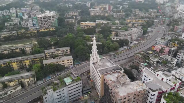 Aerial time lapse of mosque minaret in city with highway - drone flight circling shot