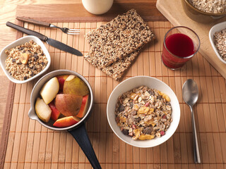 Rich breakfast with organic cereals and ingredients on a wooden table, healthy food concept