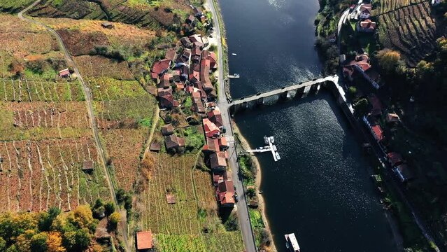 Belesar Village And Bridge With Jetty At Sil River On A Sunny Day In Ribeira Sacra, Galicia, Spain. - aerial