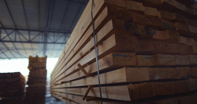 The loader brings wood in a pallet. Loading business timber in a warehouse. Woodworking industry.