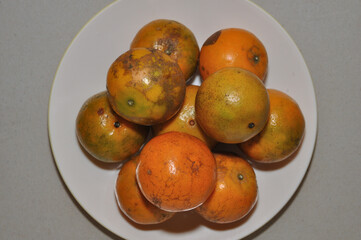 Closeup of Ripe Tangerine, Mandarin, Top view of Oranges on a white dish, on the table
