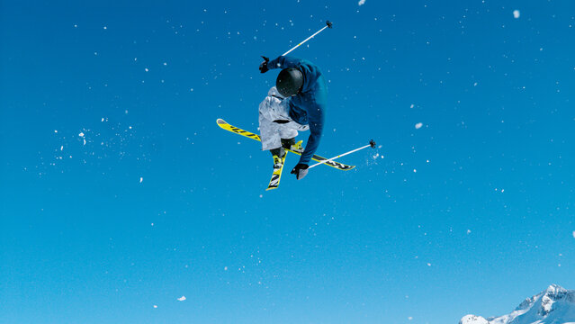 Freestyle skier takes off the kicker and does a difficult high flying 360 grab.