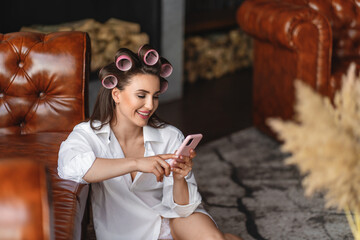 woman sitting near sofa and using phone.