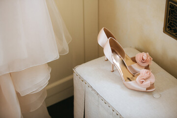 Wedding shoes on table against bridal dress
