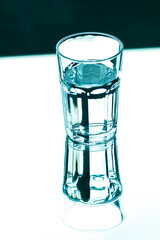 A glass with clean clear water with reflection and sharp shadows