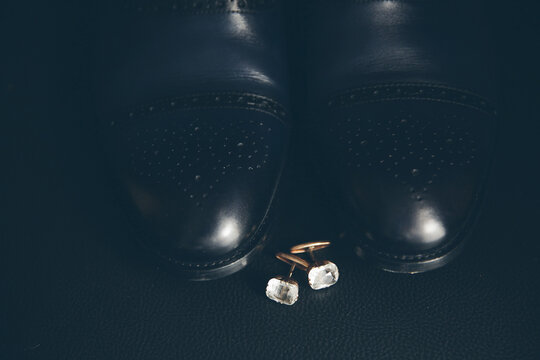 Modern boots and earrings on black background