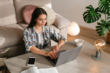 Online education concept. Young beautiful brunette woman typing on her laptop. Portrait of female...