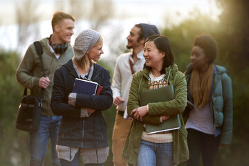 Chatting on the way to class. Cropped shot of a group of college students on campus.