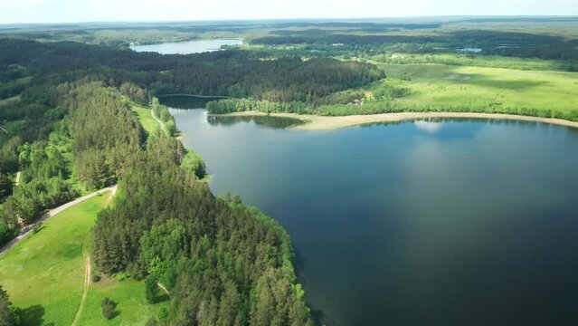 AERIAL: Flying Over Majestic Lake Over Forest on Sunny Summer Day