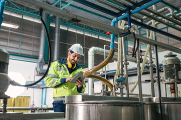 Caucasian technician engineer man in uniform with tablet checking and control boiler tanks and...