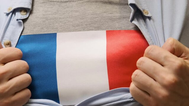 Man unbuttons his shirt and reveals a France flag t-shirt. Right to independence. Patriotism.