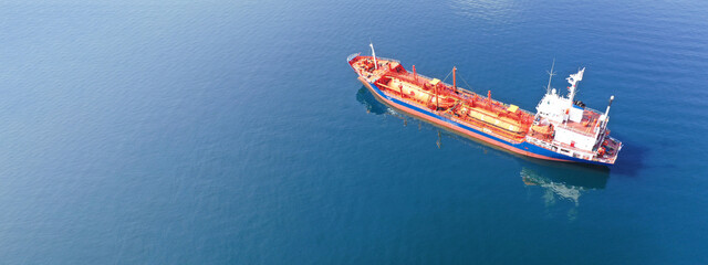 Aerial drone ultra wide top down photo of industrial LPG gas tanker ship anchored in deep blue sea
