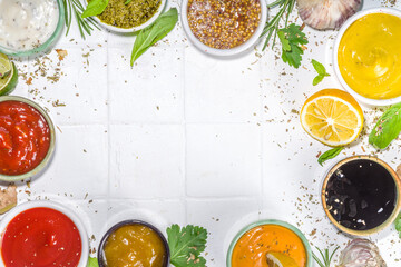 Assortment of different classic sauces and dips in sauceboats. Mayonnaise, ketchup, tartare, mustard, pesto, sour cream, barbecue sauces with spices, herbs, lemon