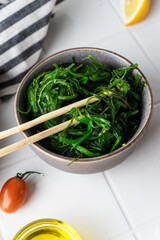 asian chuka salad with minerals and vitamins. on a light background in the composition. beautiful serving in a plate. diet snack