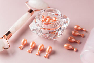 Pink quarts face roller and single dose serum capsules in a package. Facial massage. Natural...