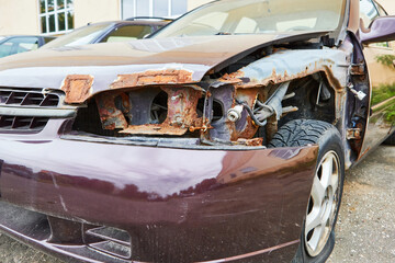 car after the accident with rust without headlight and car fender close-up