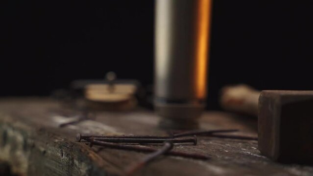Rusty nails falling on wooden plank table in slow motion