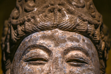 Fototapeta na wymiar Close-up of eyes expression of Buddha statue in stone carving of ancient Chinese Buddhist temple