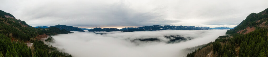 Aerial Panoramic View of Canadian Mountain Landscape covered in fog over Harrison Lake. Winter Season. British Columbia, Canada. Nature Background Panorama