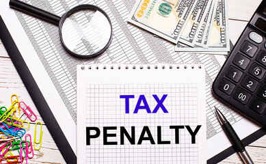 On the office table there is a notebook with the text TAX PENALTY, a pen, a calculator, dollars,...