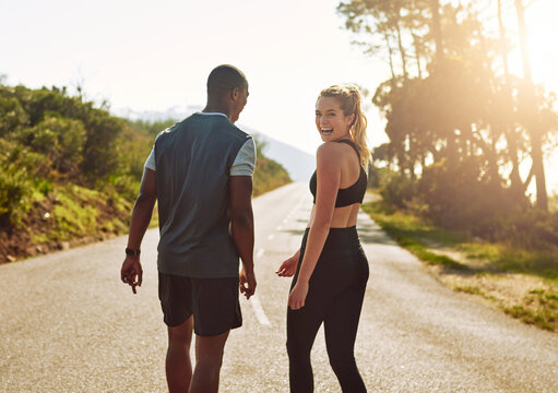 My guy makes the best workout buddy. Shot of a fit young couple slowing down for a walk during their run outdoors.