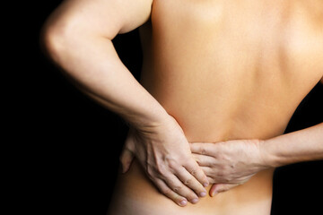 Man with side pain on black background. Shirtless person suffering from backache, diseases of the spine and lower back