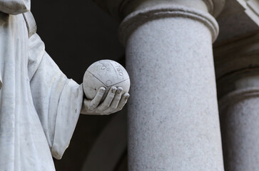 detail of a marble sculpture with a hand holding a world-sphere. Monument in a public place with sculpture to geometry, in memory of  astronomer mathematician bonaventura cavalieri, created in 1844. - obrazy, fototapety, plakaty