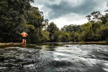 A man standing at the river with natural background, travel concept.