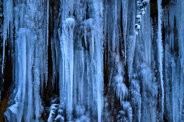 Icicles on the rock. Frozen waterfall in winter.