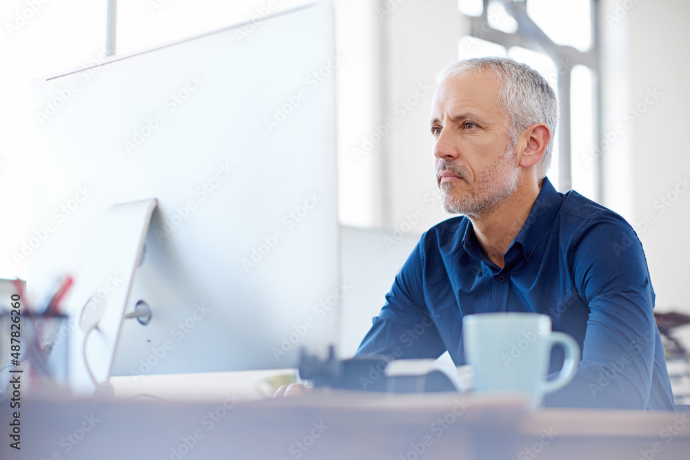 Aufkleber He has years of design experience behind him. Shot of a mature designer working on a computer at a desk in an office.