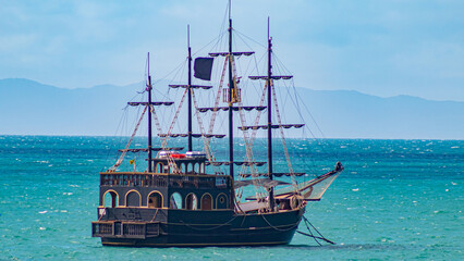 barco pirata no mar azul esverdeado na praia da Cachoeira do Bom Jesus Florianópolis Santa...