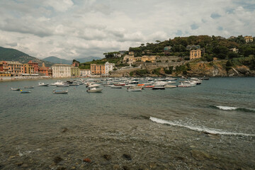 Scenic marina view of monument in the bay of the Silence in Sestri Levante, Liguria, Italy across the colorful houses, mountains and coastline
