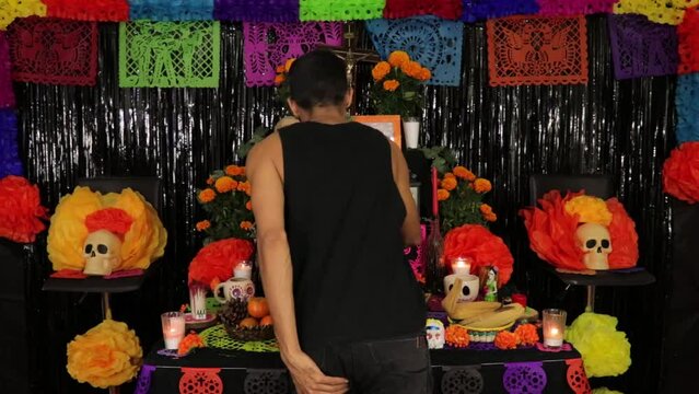 Making the offering for the day of the dead. Light candles. Time lapse. A handsome brown skin model. Mexicam decoration for d�a de muertos. 