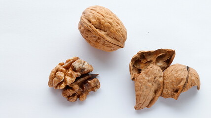 A group of awallnut, cracked walnuts and walnutshell isolated on white background. top view